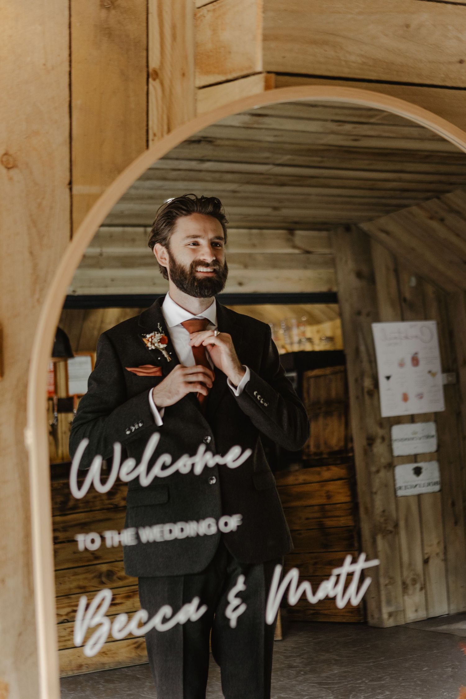 Wedding welcome sign with elegant script lettering displayed in a rustic wooden venue.