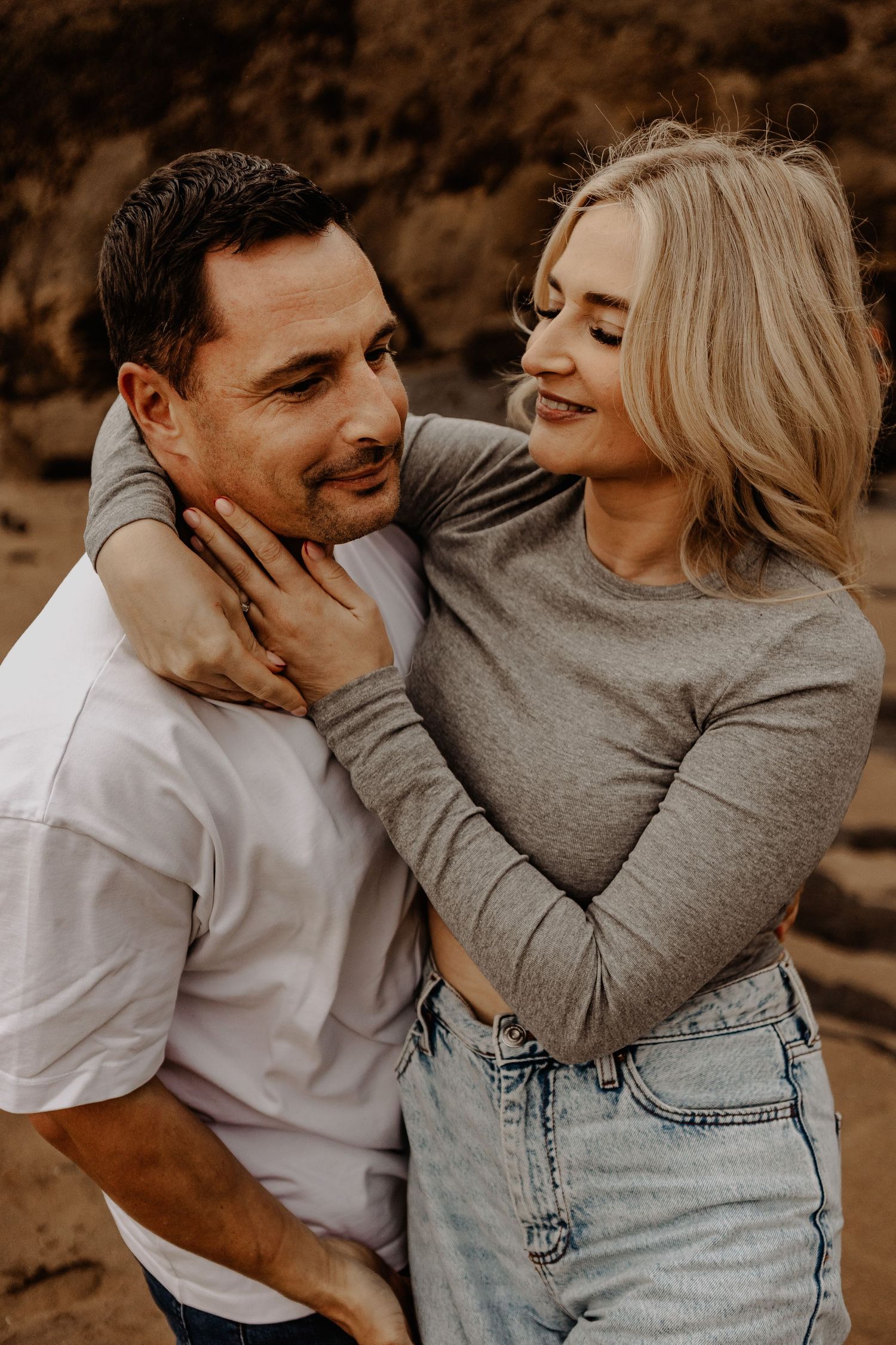 A romantic couple in casual attire sharing intimate moments in a sepia-toned photo series.
