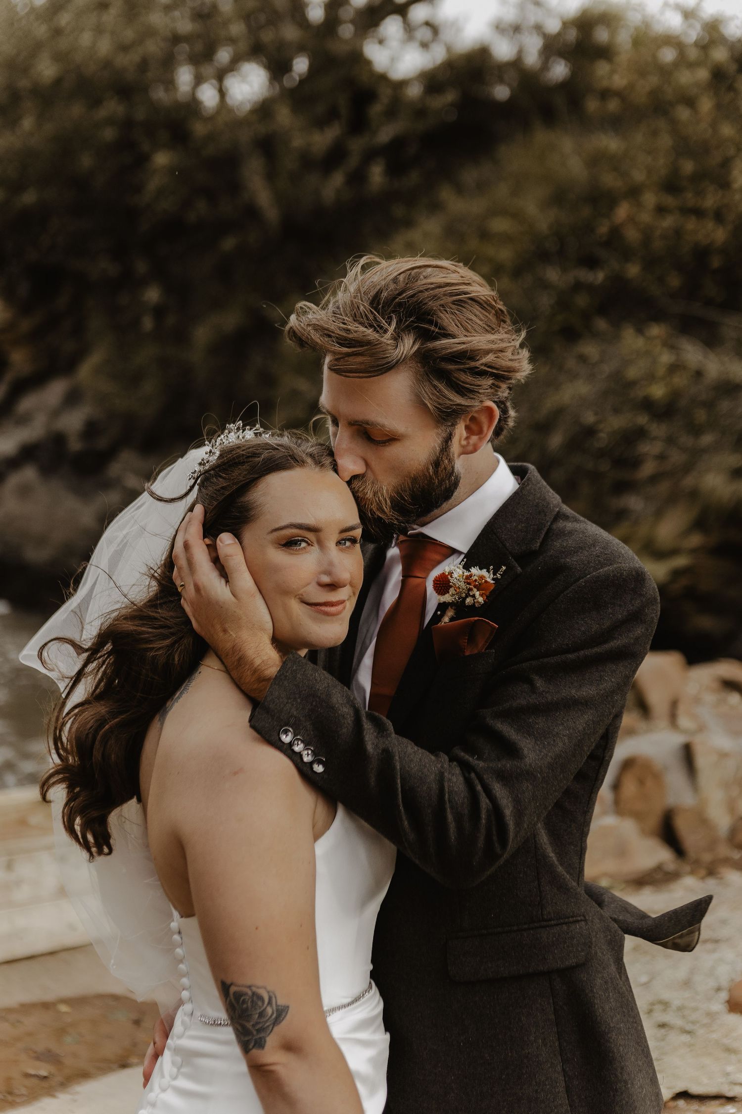 Intimate moment between newlyweds in a romantic outdoor setting.