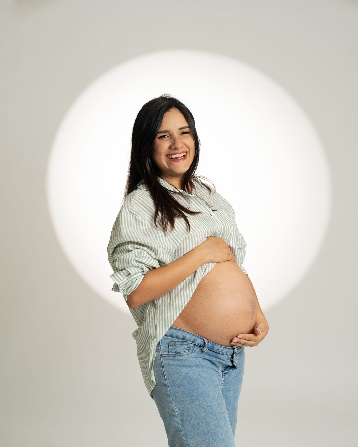 Elegant maternity studio session with creative lighting.
Sesión de fotos de embarazo elegante con luz de estudio