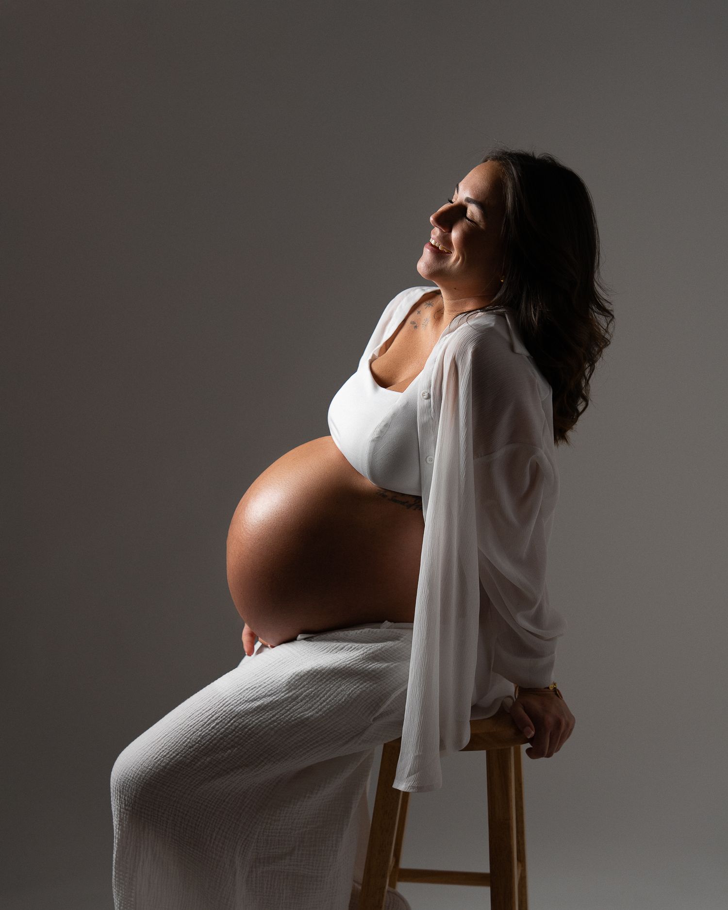 Elegant maternity studio session with creative lighting.
Sesión de fotos de embarazo elegante con luz de estudio