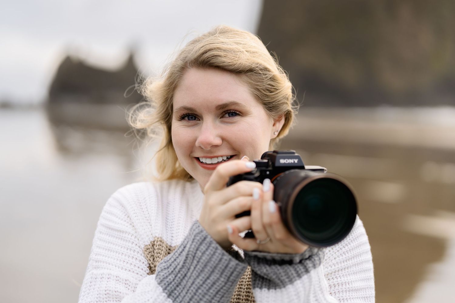 Professional photographer with long lens camera taking outdoor portrait photos during golden hour lighting session.