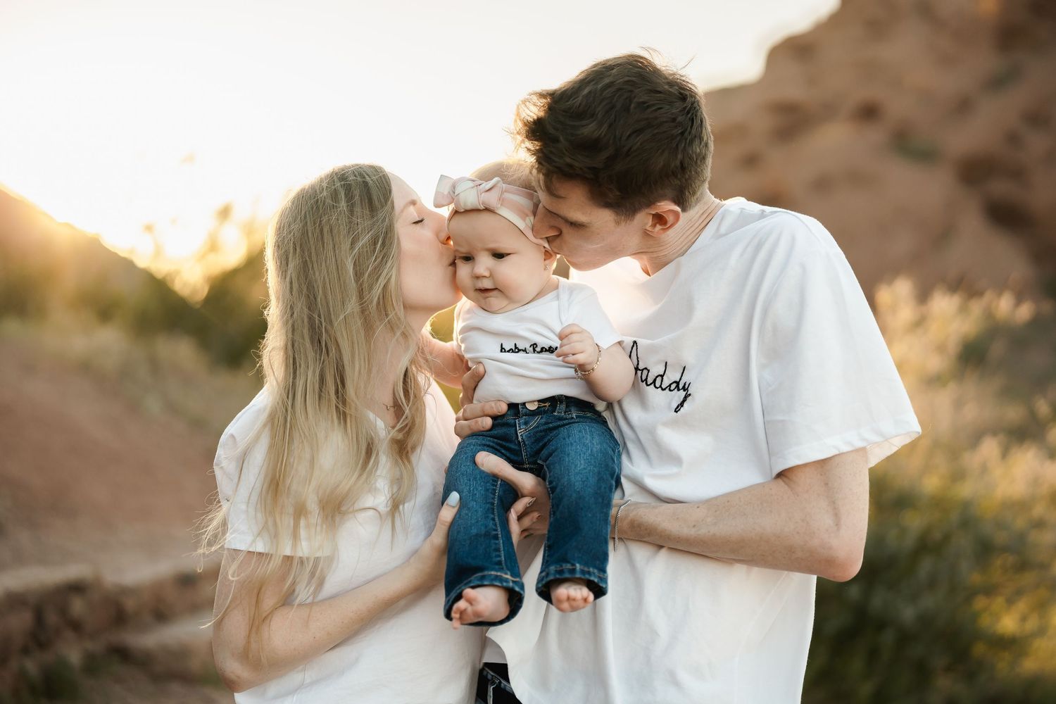 A whimsical outdoor photo session shows a couple sharing intimate moments at golden hour in a desert landscape.