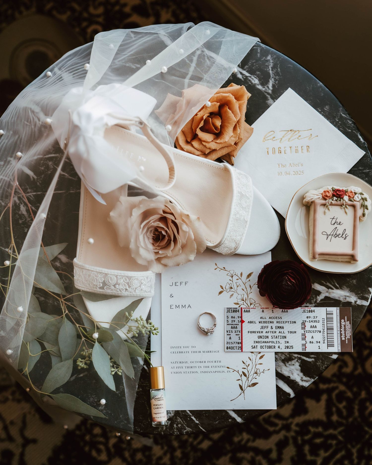 Wedding details including rings, floral arrangements, invitations, and delicate accessories arranged in a romantic style.