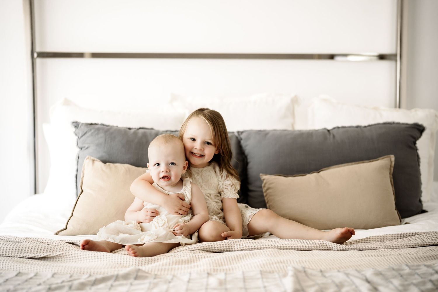 Collage of baby in white onesie laying on gray bed sheets and cozy pillows in natural light setting.