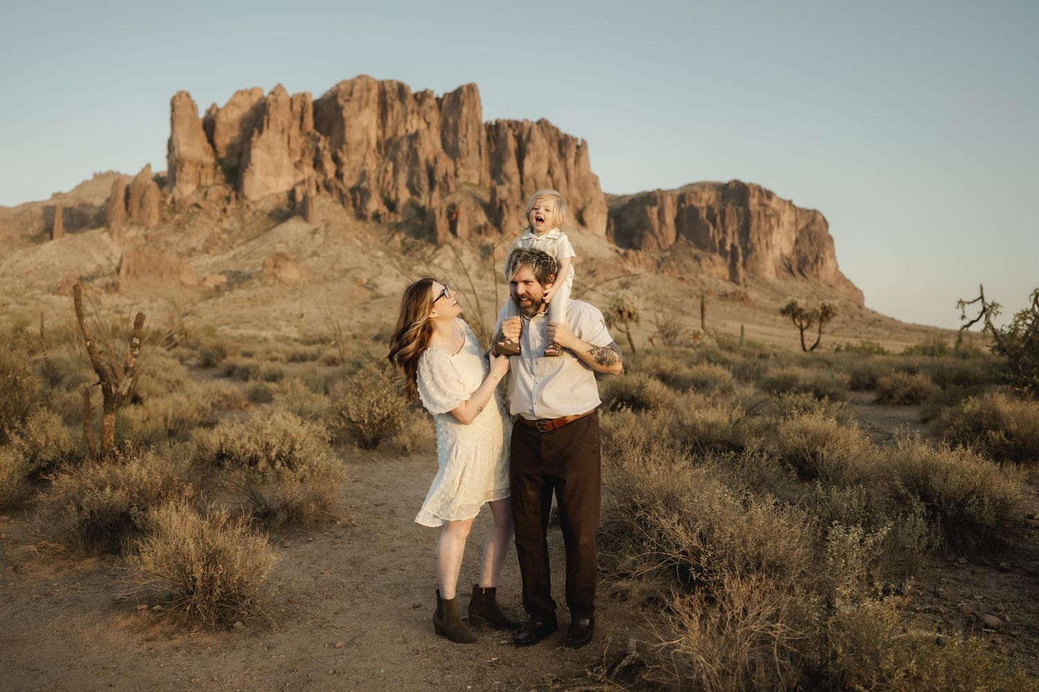 Family portraits with desert mountains and saguaro cacti in the background at golden hour.