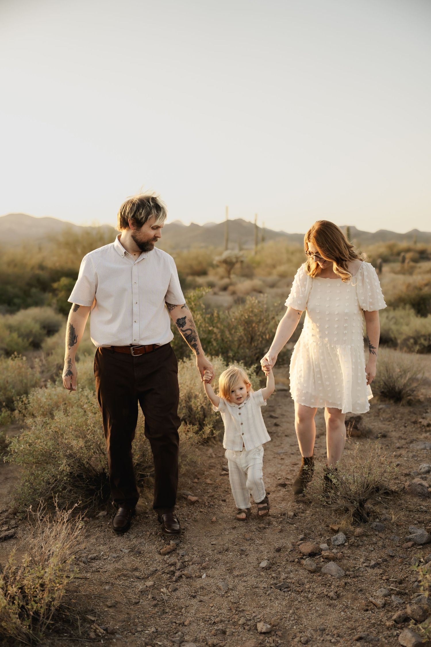 A family walking together on a desert trail during golden hour.