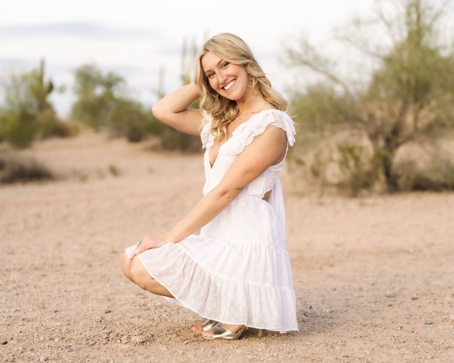 A soft desert landscape provides a natural backdrop for outdoor portrait photography.