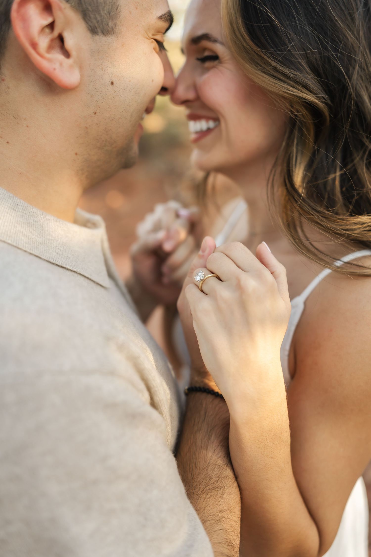 Close-up romantic moment with ring visible during engagement or wedding photoshoot.