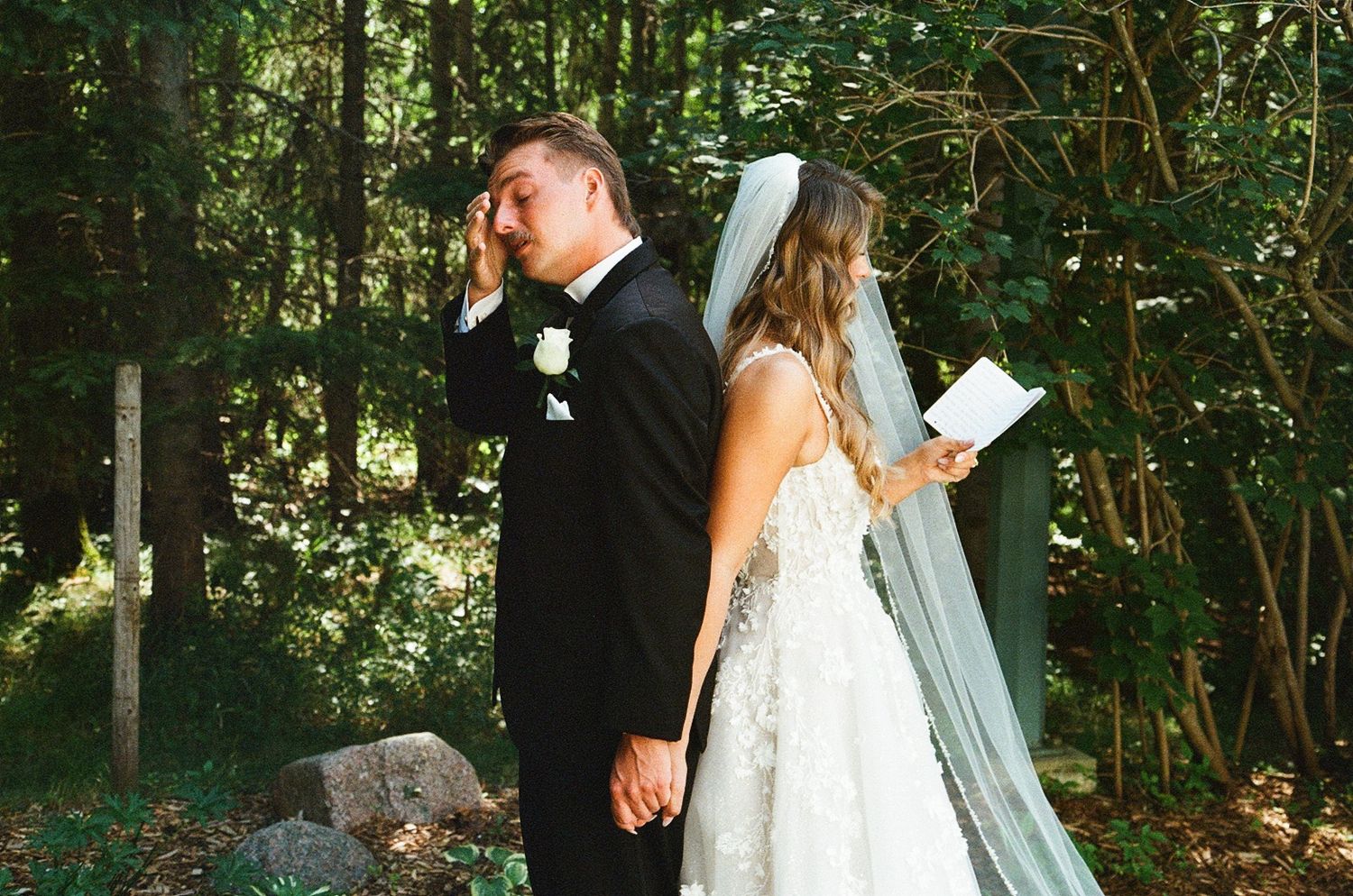 Bride and groom share emotional first-look moment in forest, exchanging private vows before outdoor woodland wedding ceremony.
