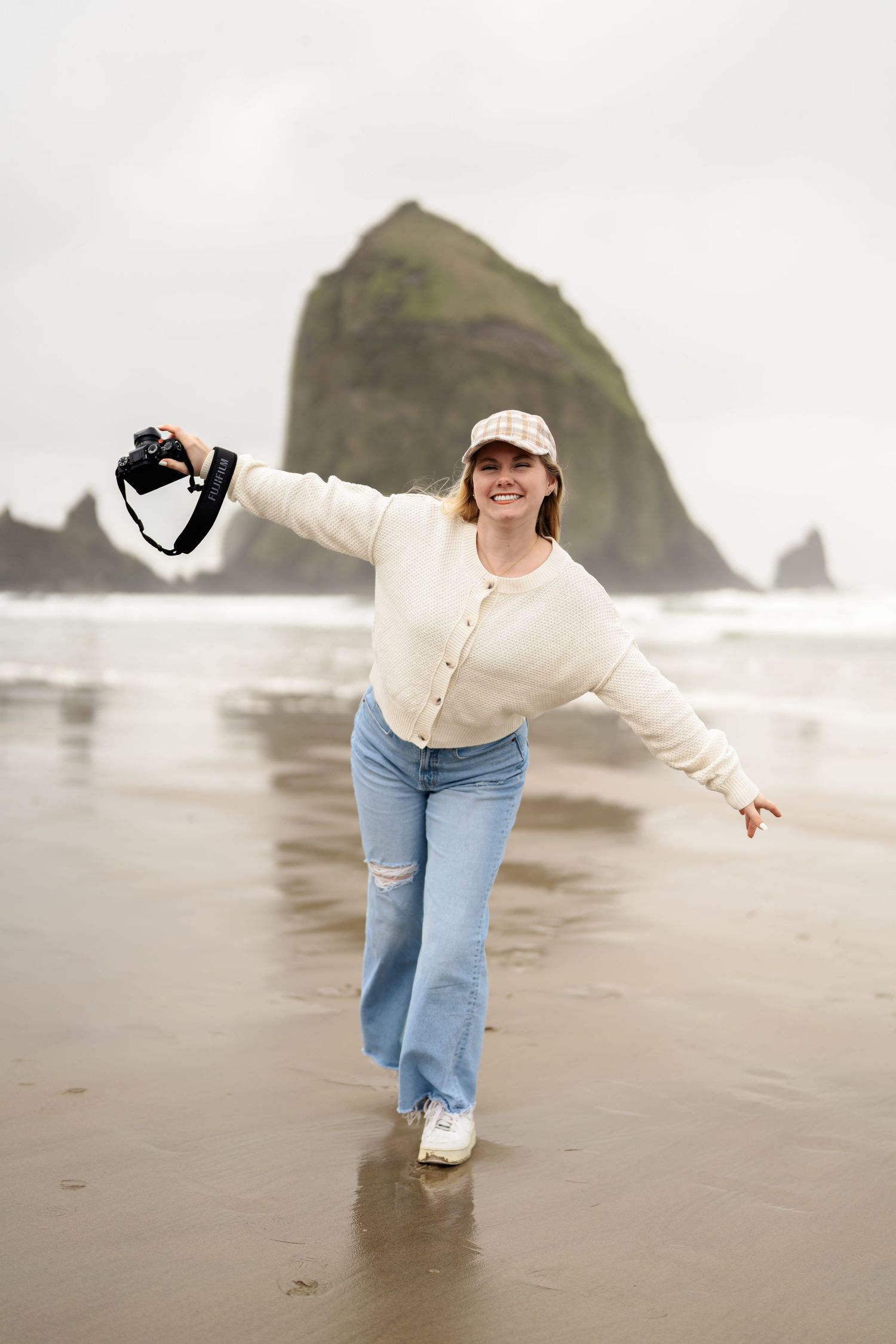 Playful beach photography session at Haystack Rock on Oregon coast in casual attire.