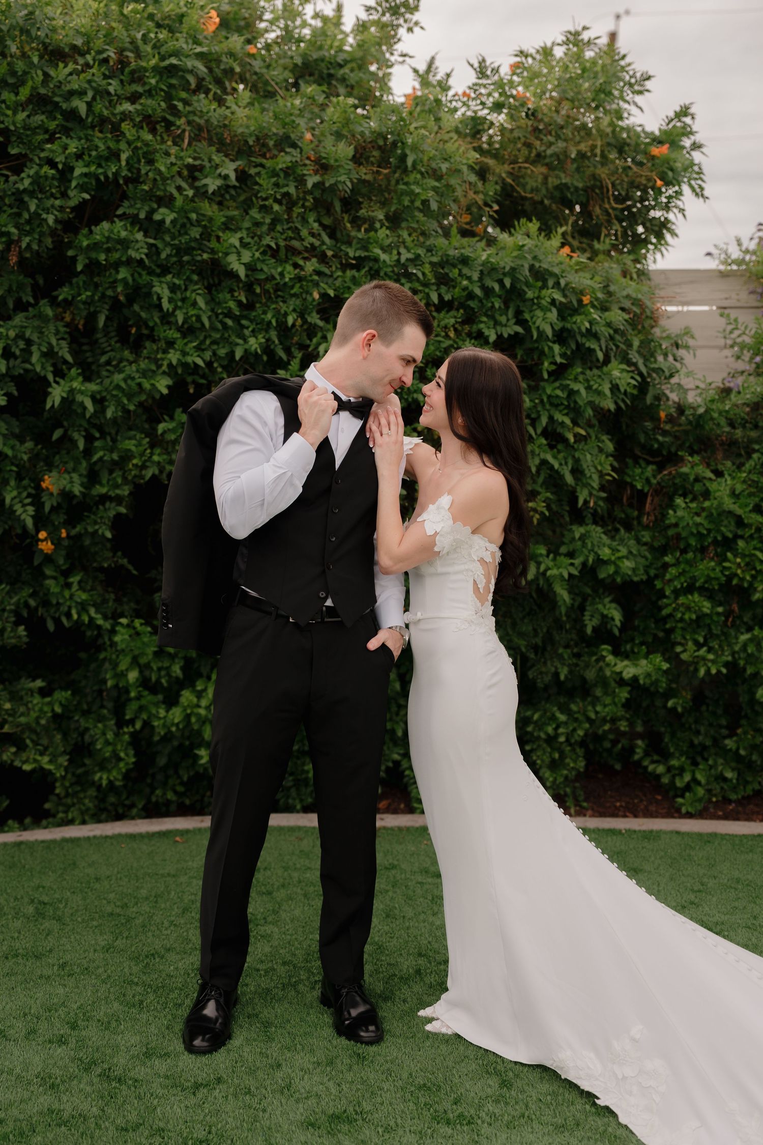 A romantic wedding moment captured in a garden setting with citrus trees.