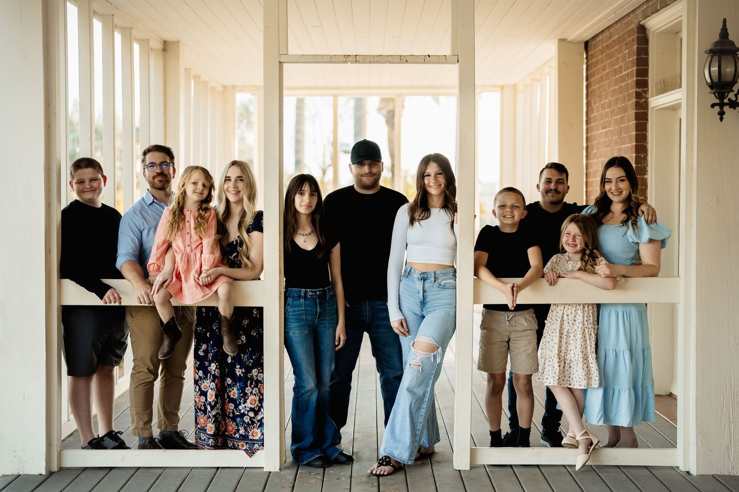 Large group portrait of people standing together in bright indoor space.