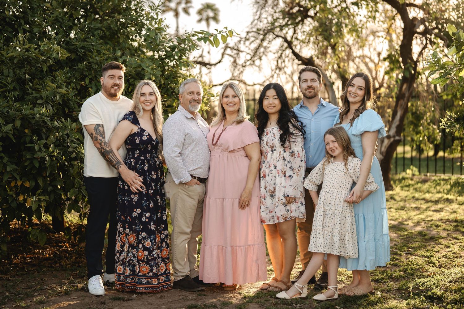 Extended family group portrait session outdoors with coordinated pastel and floral outfits.