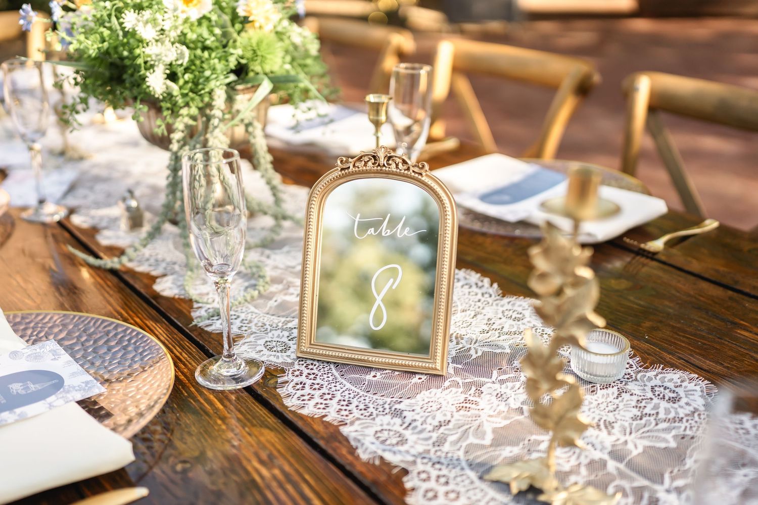 Elegant table settings with delicate lace details and floral centerpieces at wedding reception.