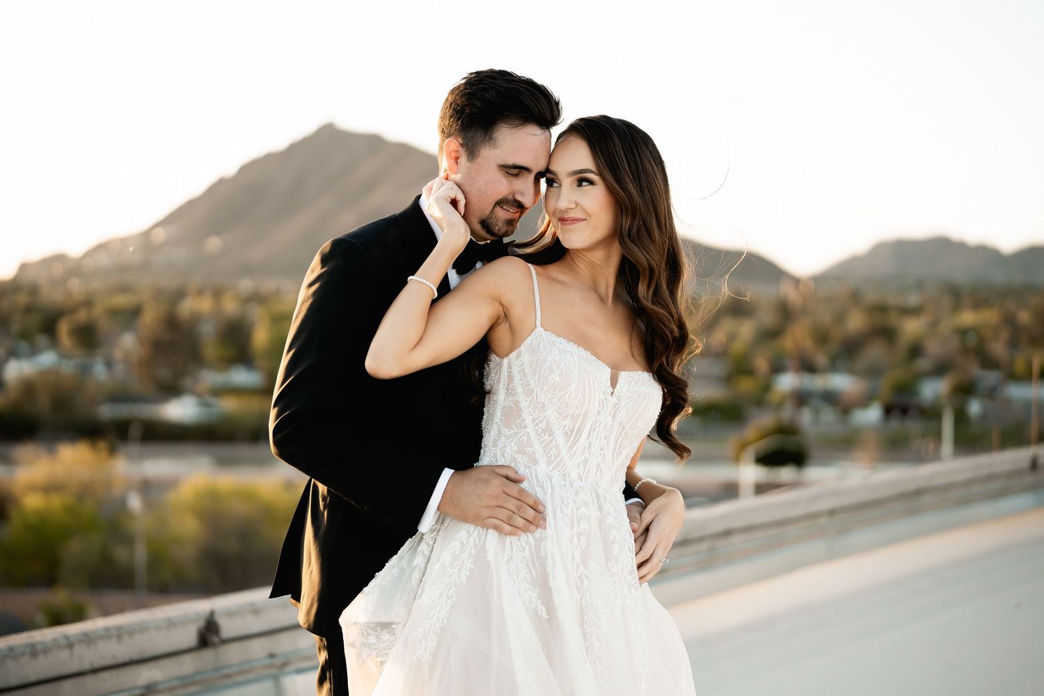Intimate desert engagement portrait session showing tender moments against mountainous backdrop.