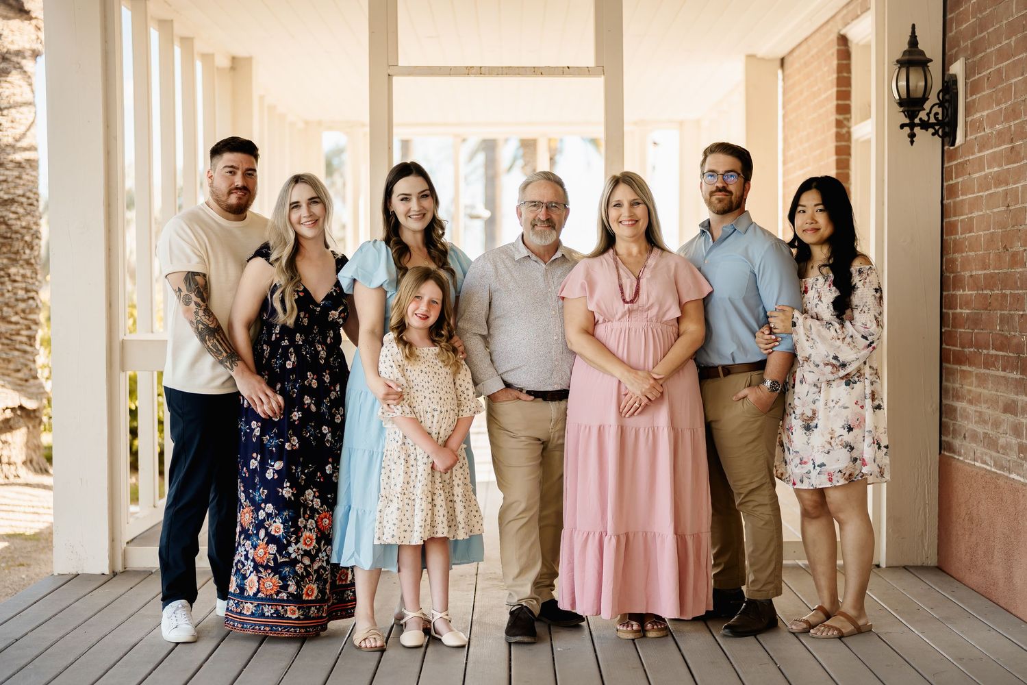 Large family gathering posed together on a classic white columned porch.