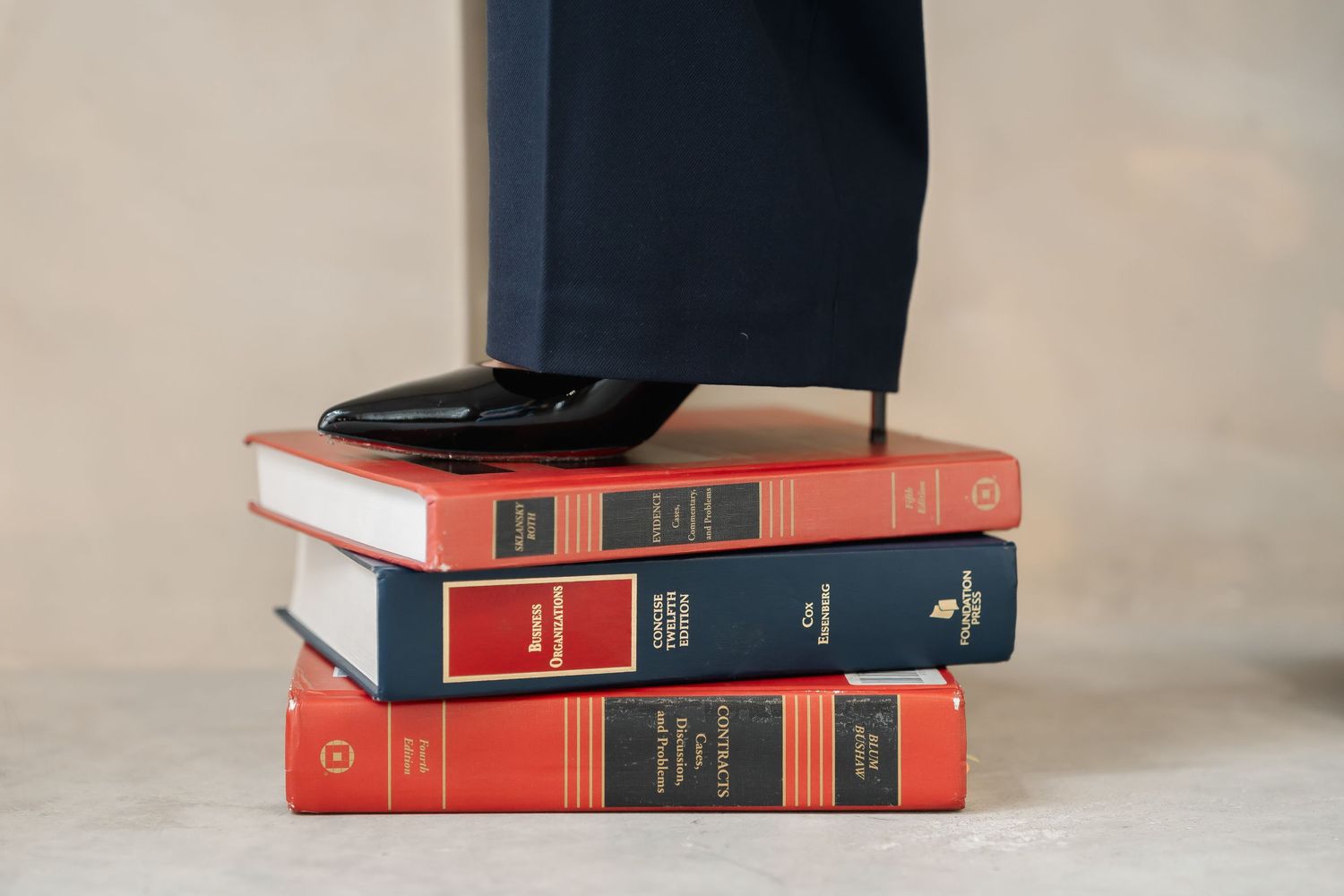 Stack of red and black hardcover books against a neutral background.