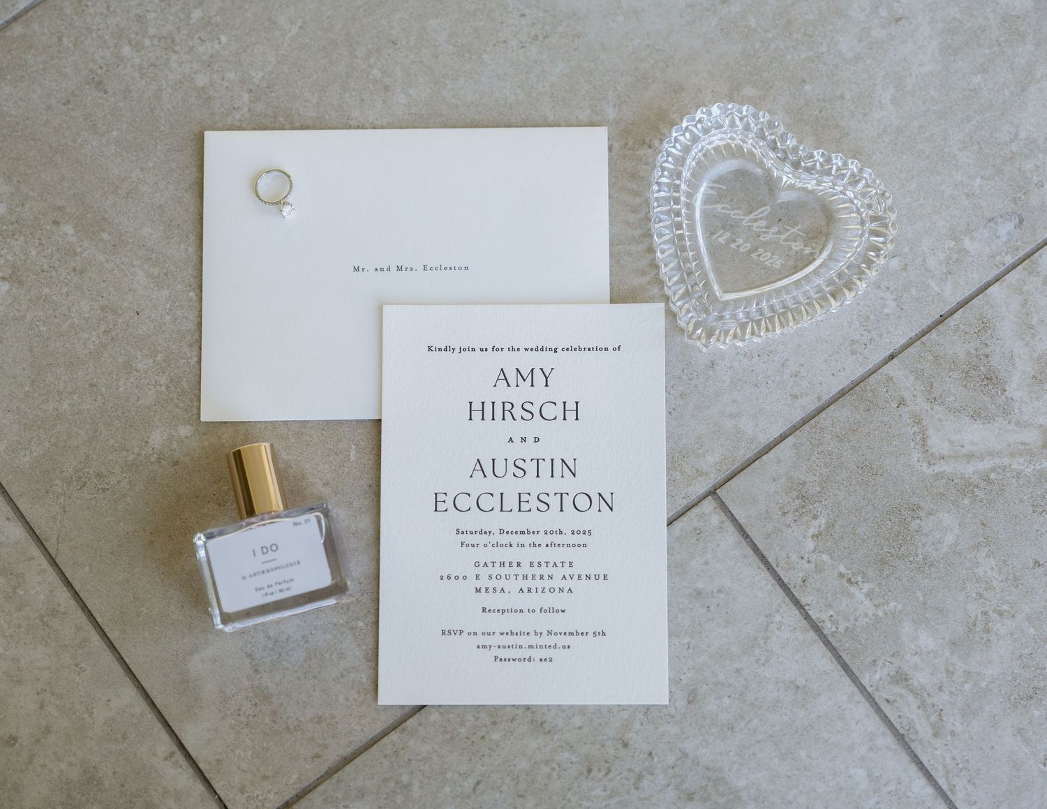Elegant white wedding invitation cards and envelopes arranged on a light gray textured surface.