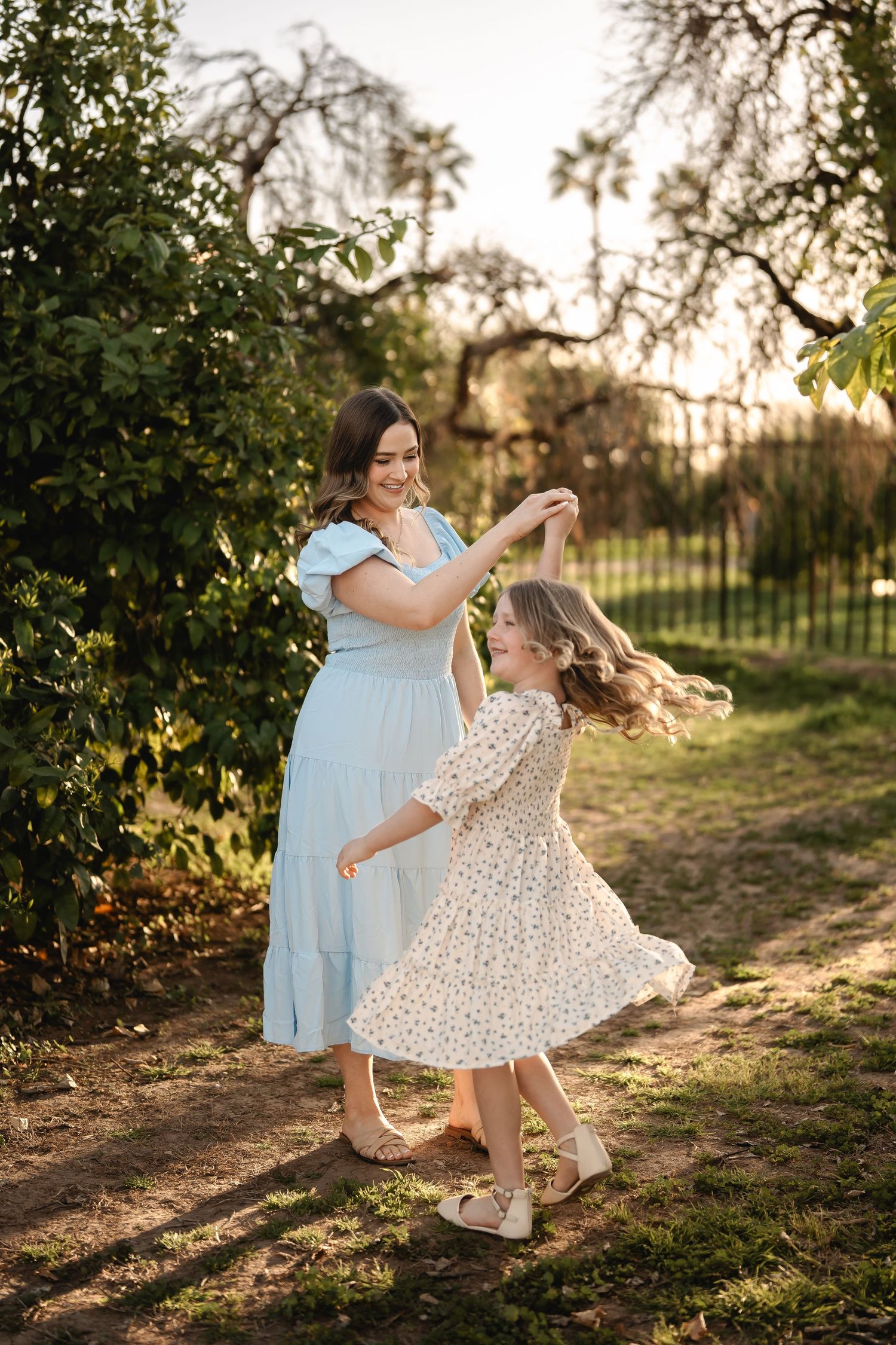 Sweet outdoor portrait session showing tender bonding moments in a sunlit garden with soft golden light.