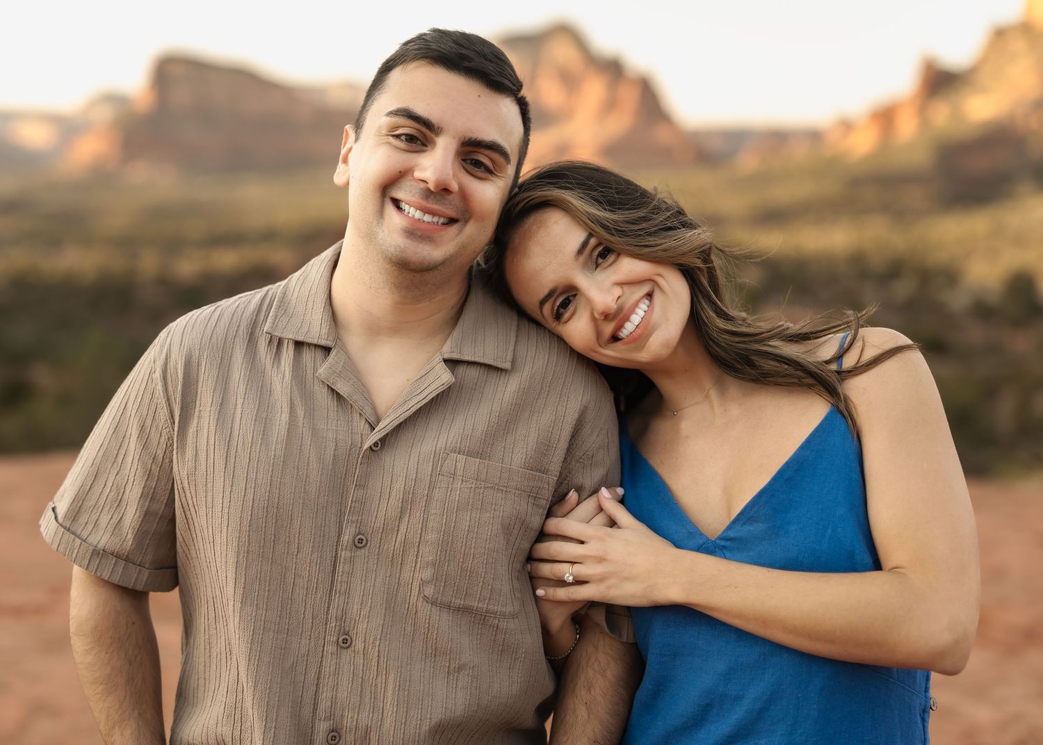 A couple shares tender moments at sunset with desert mountains in the background.
