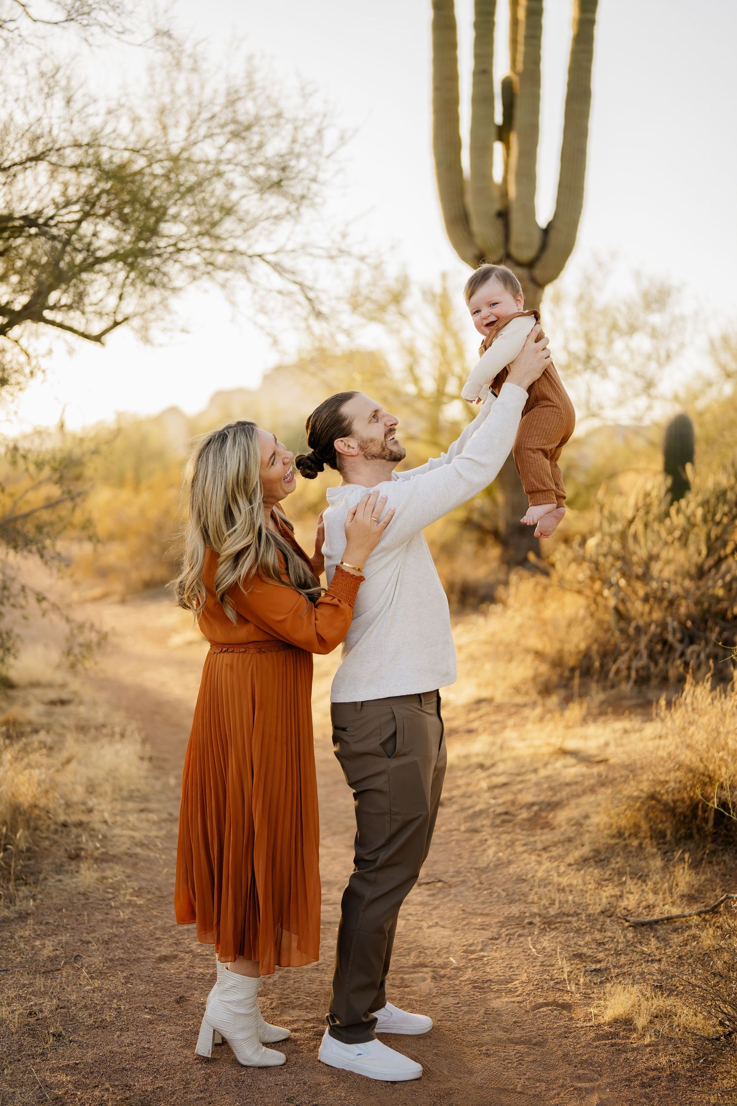 Playful family moments captured in desert setting with saguaro cactus backdrop.