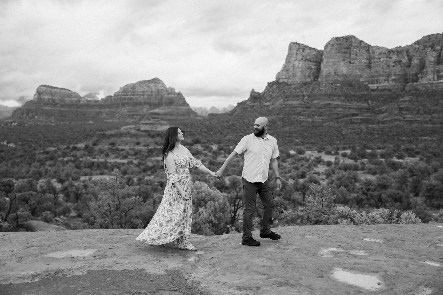 Black and white wedding photography with majestic desert cliffs as backdrop.