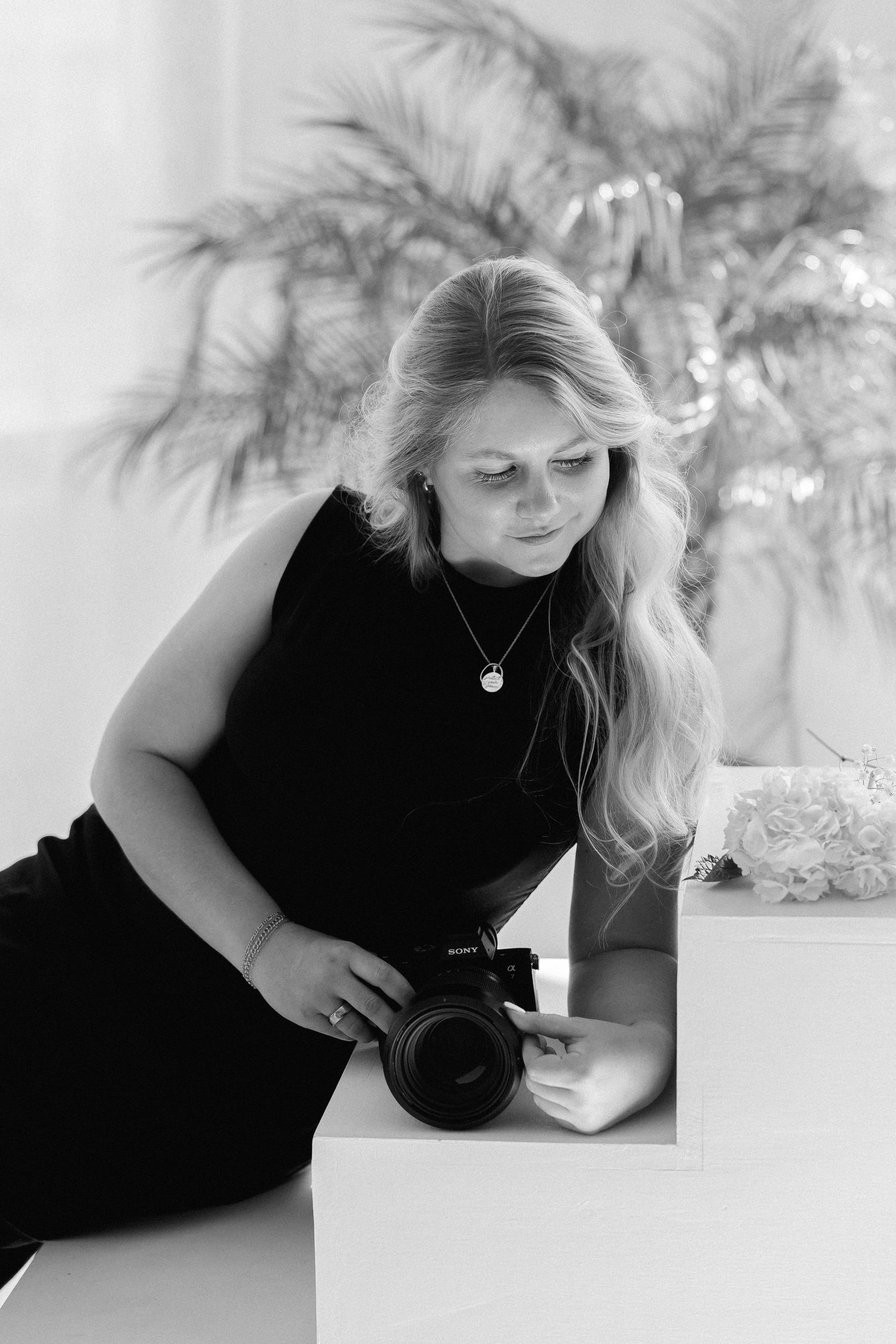 A person in a black top lies on a white surface while photographing in an artistic series of progressive poses.