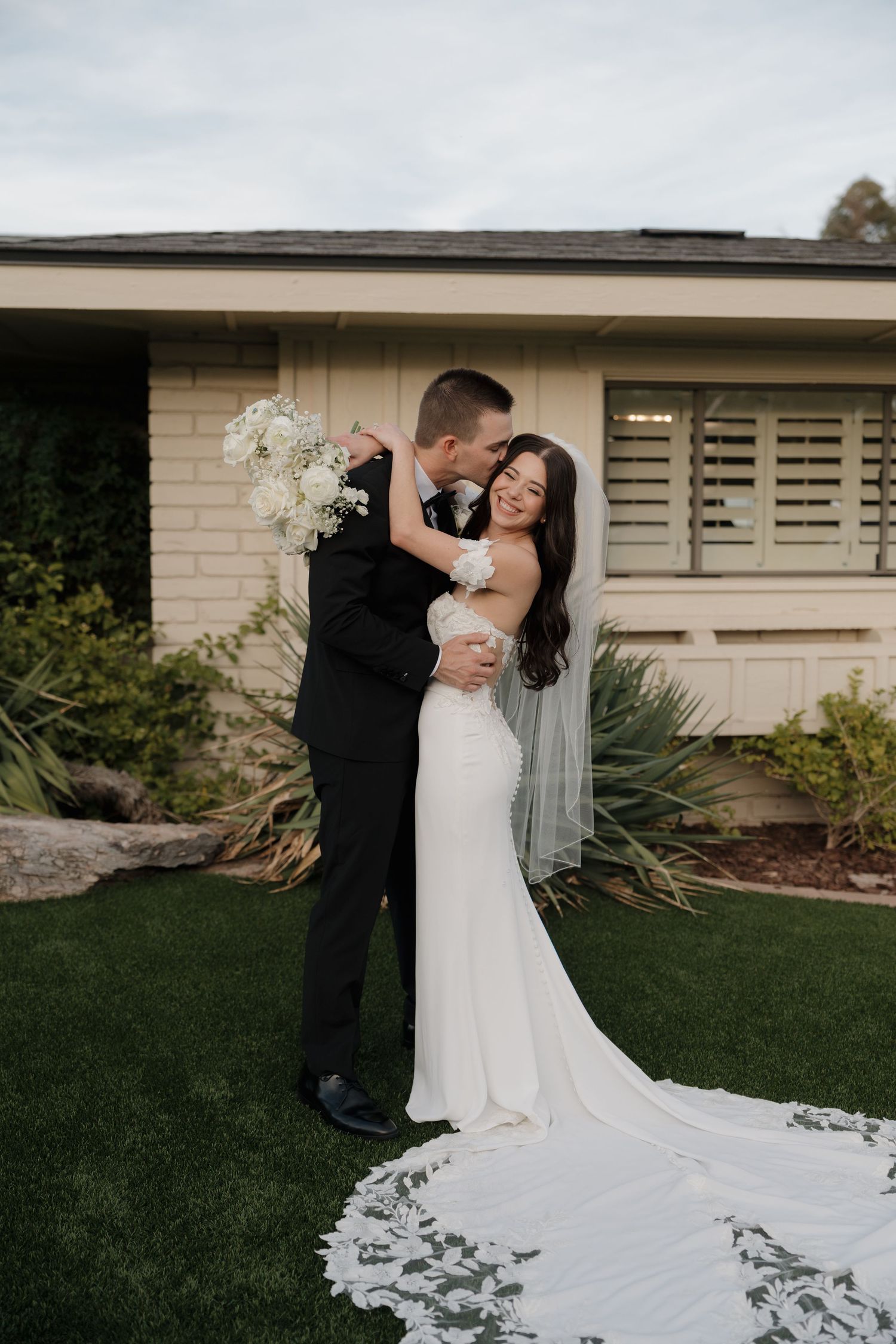 Romantic outdoor wedding photography sequence showing a couple embracing with a flowing white wedding dress train.