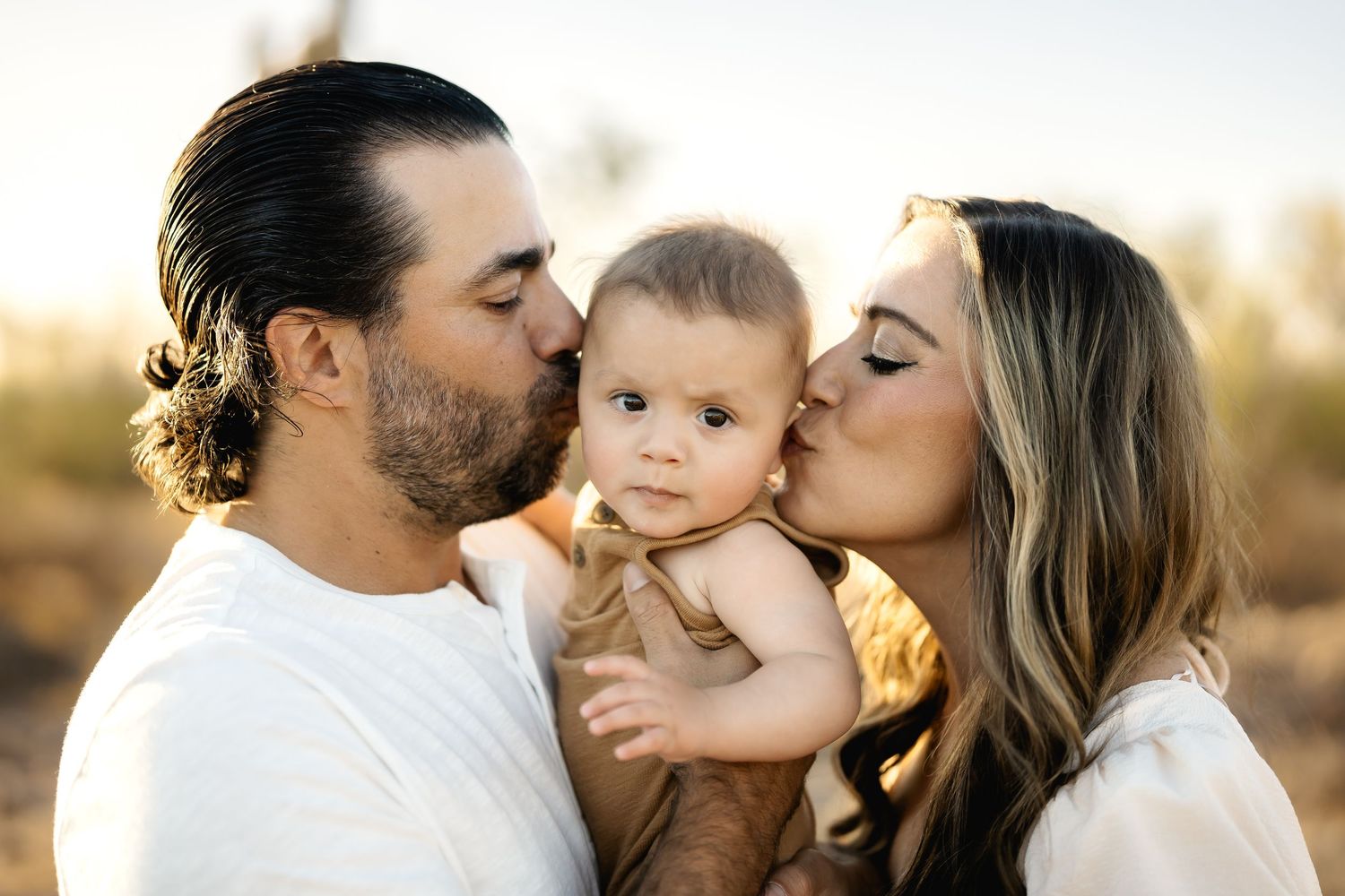 Sweet family moment captured during outdoor golden hour portrait session.