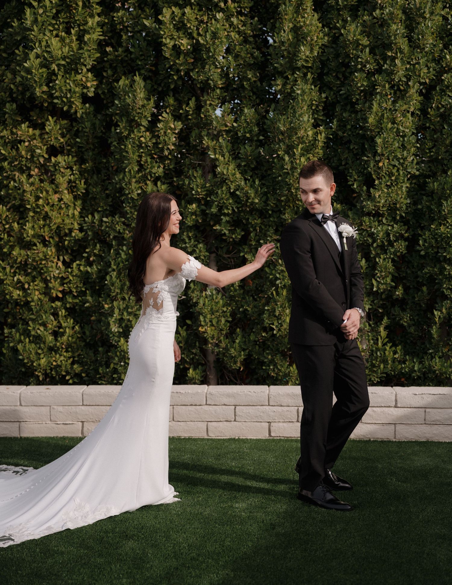 Artistic sequence showing a first look moment between wedding couple in front of greenery.