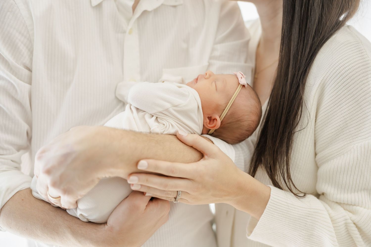 Intimate family moments captured on white bedding in natural lighting.