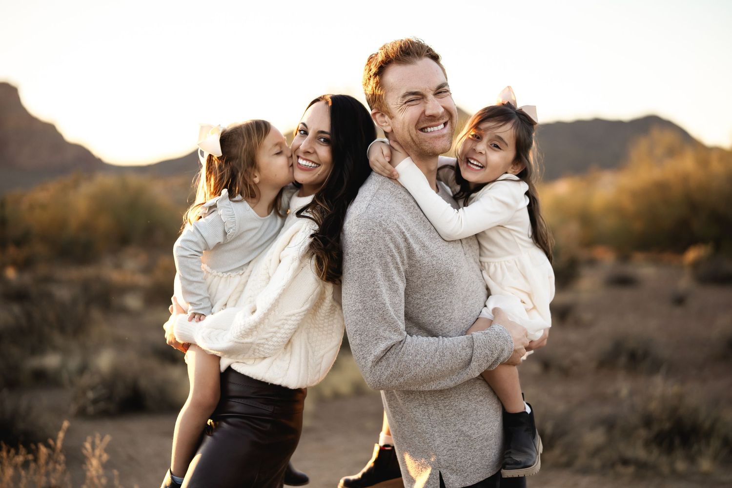 Candid engagement photo series showing couples embracing in desert landscape at sunset.