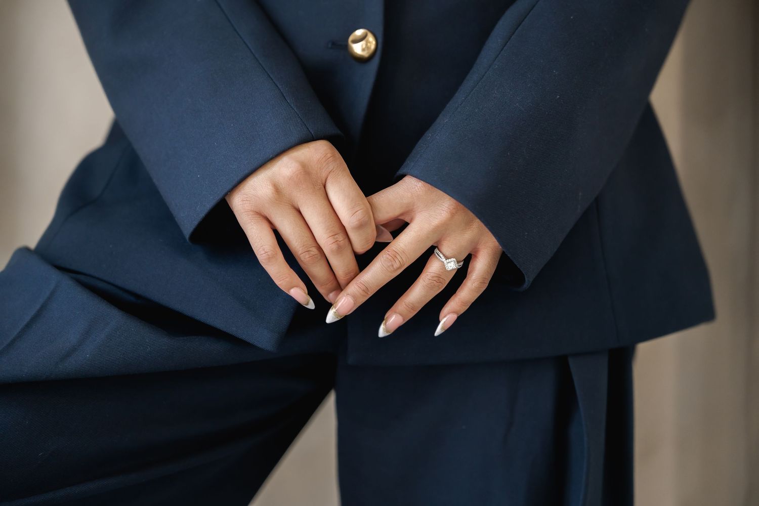 Close-up details of a navy blue formal suit with gold button.