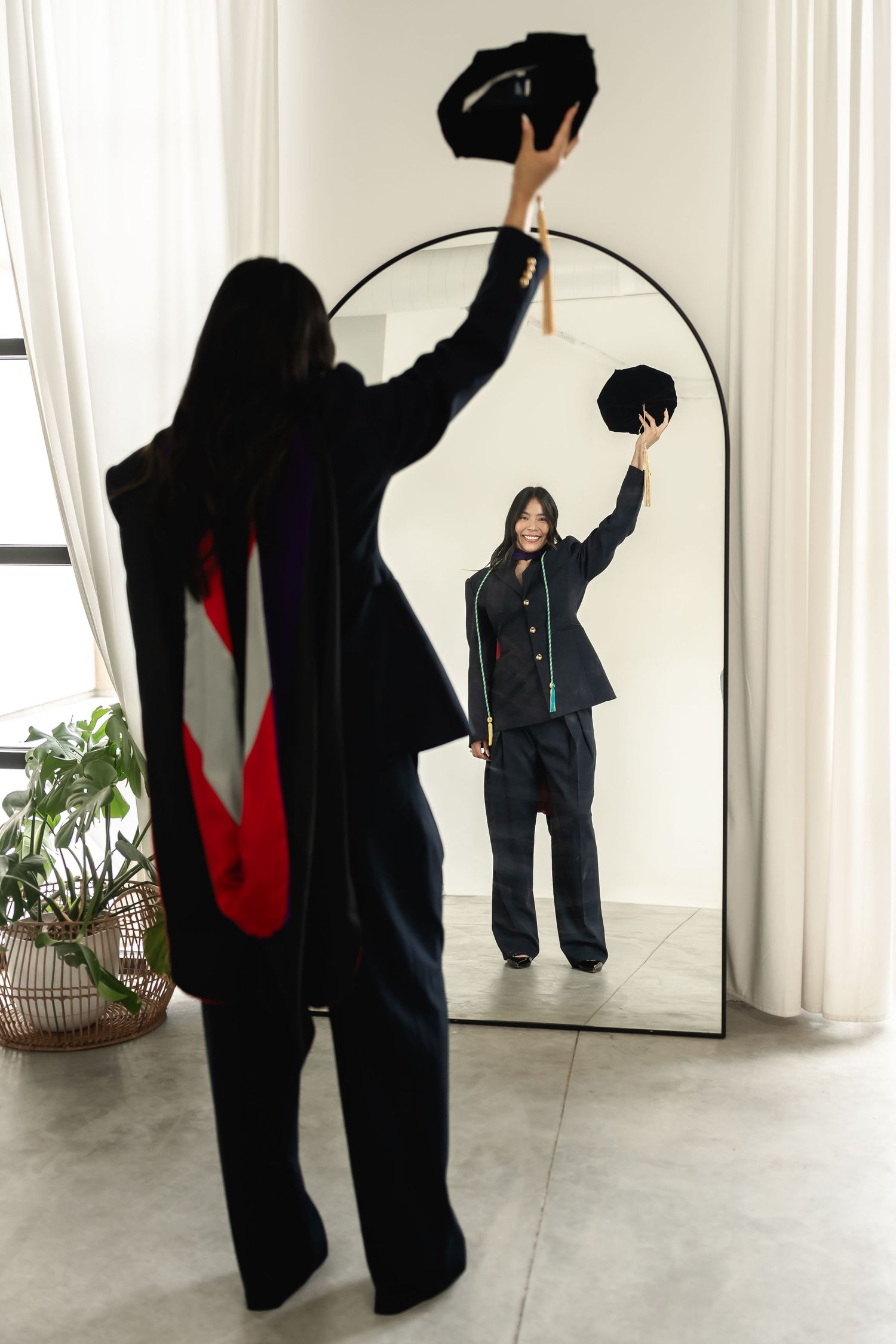 Artistic graduation photo series with dramatic poses and black graduation gown.