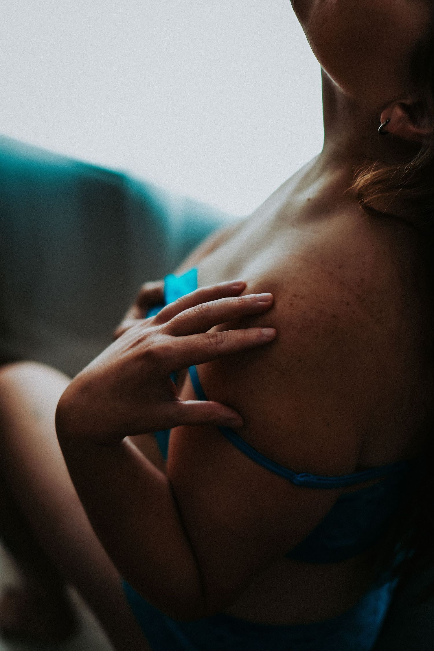 Close-up view of bare skin with shadows in artistic moody lighting.