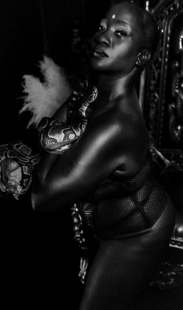 Artistic black and white portrait photograph showing delicate lace details and dramatic shadows.