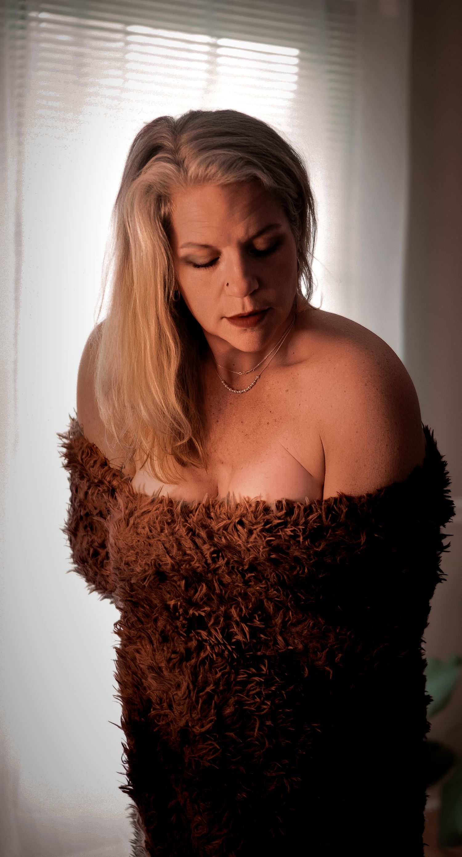 A figure in a dark brown textured off-shoulder dress poses against a light background in a series of artistic portraits.