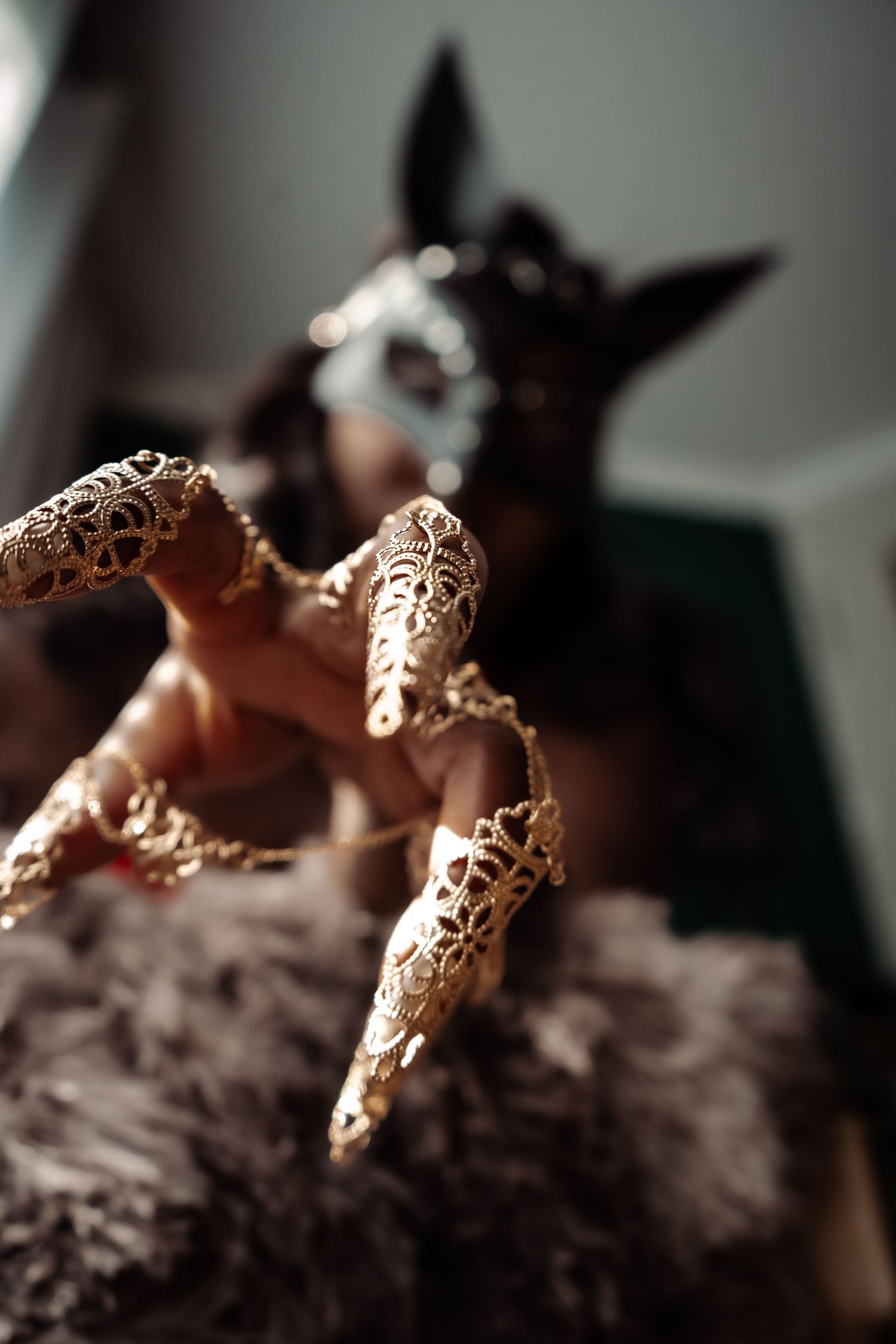 Multiple decorative brass rings with intricate filigree patterns displayed on uneven textured surface in soft lighting.