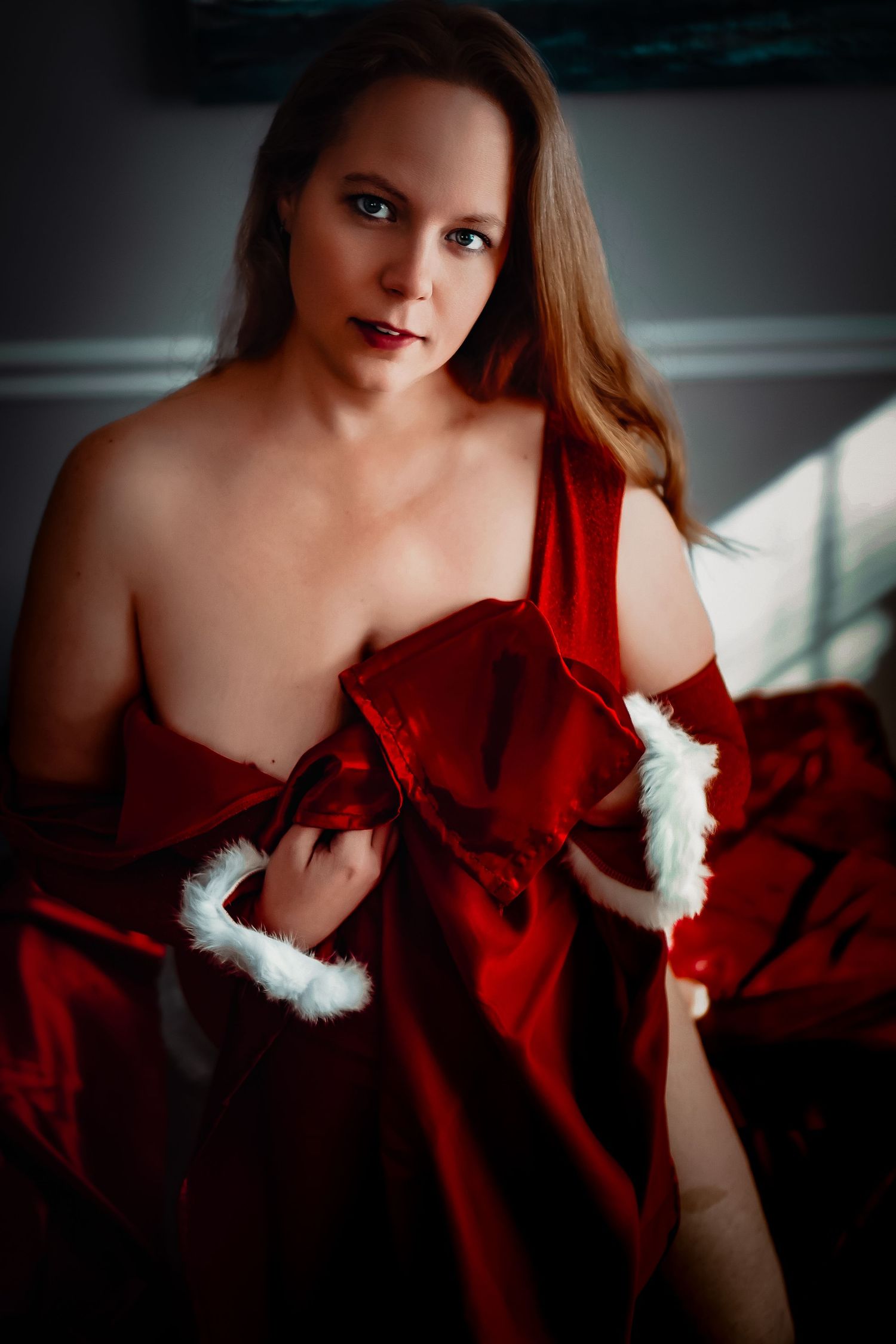 A series of glamour portraits featuring dramatic red fabric and intimate boudoir-style poses in low light.