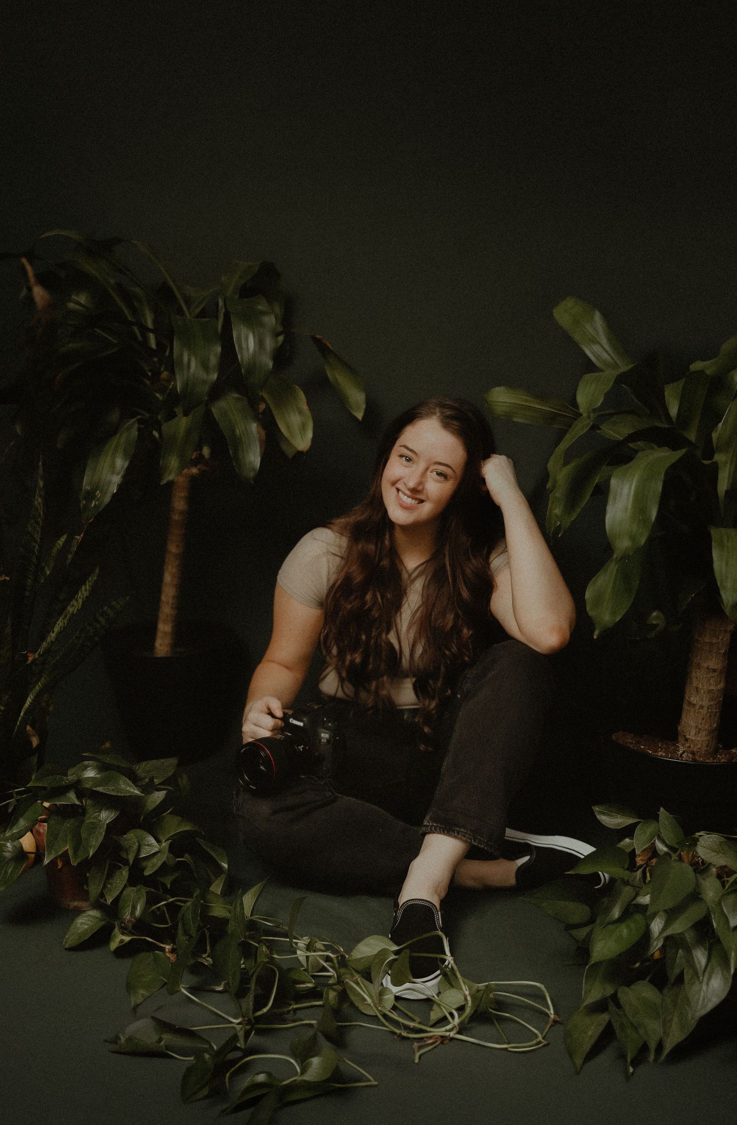 A relaxed portrait session with tropical plants and dark moody lighting.