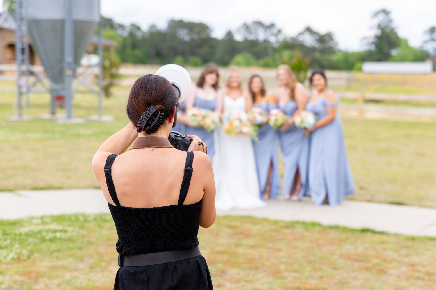 A Raleigh wedding photographer holding her camera taking a photo of a bridal party.