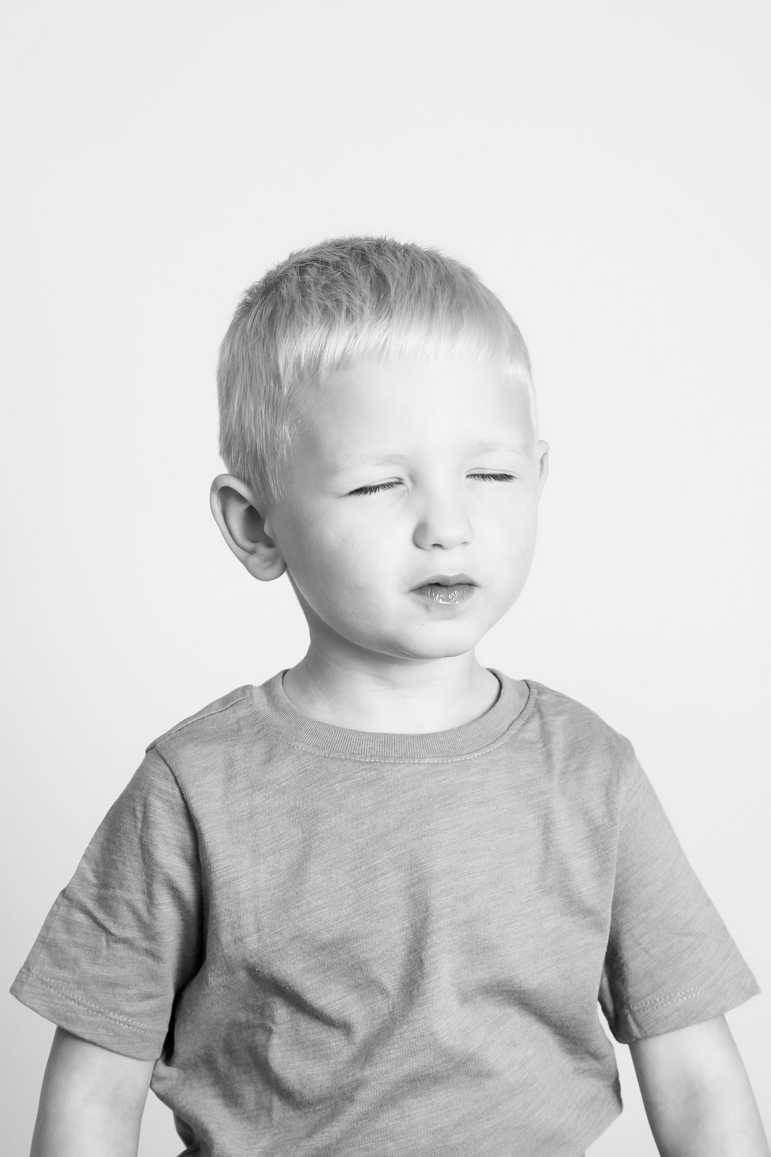 Black and white studio portrait showing gentle expression in casual t-shirt.