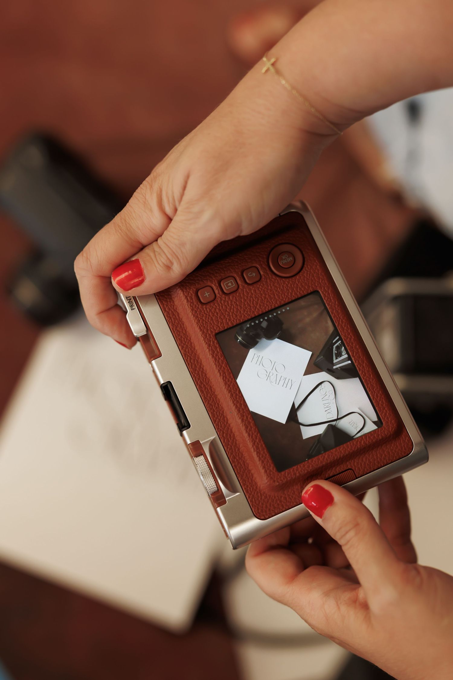 Hands demonstrating a sequence of opening a brown leather wallet pocket to reveal a hidden photo compartment.