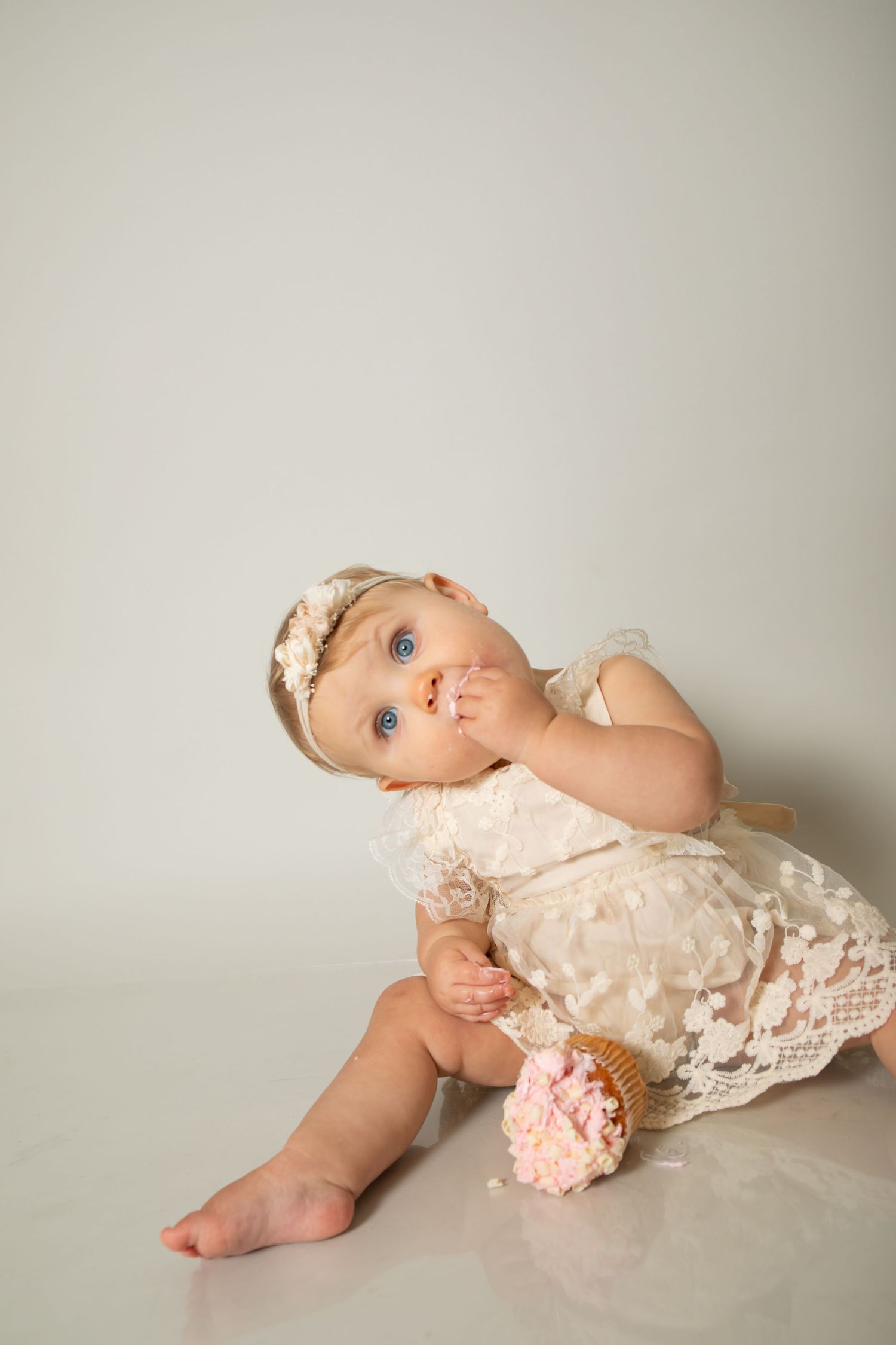 A delicate portrait of a toddler in a lace dress with vintage styling.