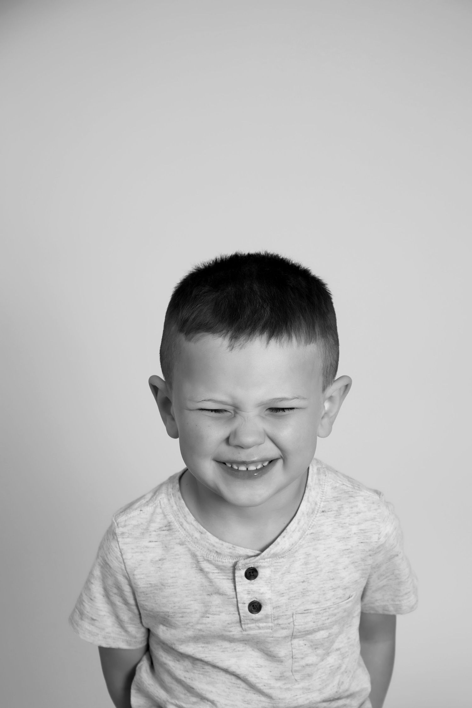 Black and white portrait showing joyful expression and casual henley shirt.