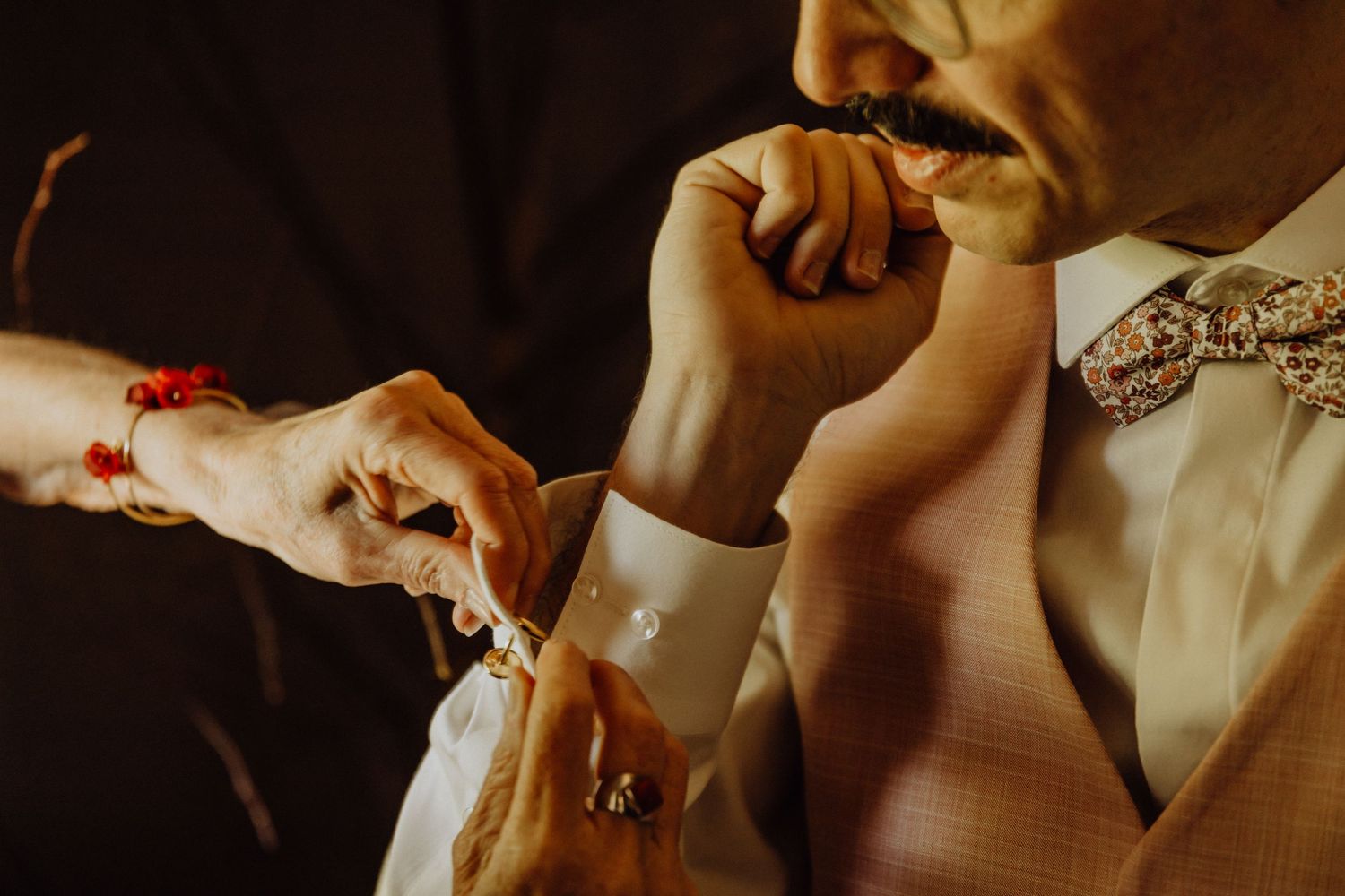 Close-up view of hands holding and exchanging wedding rings during a traditional ceremony.