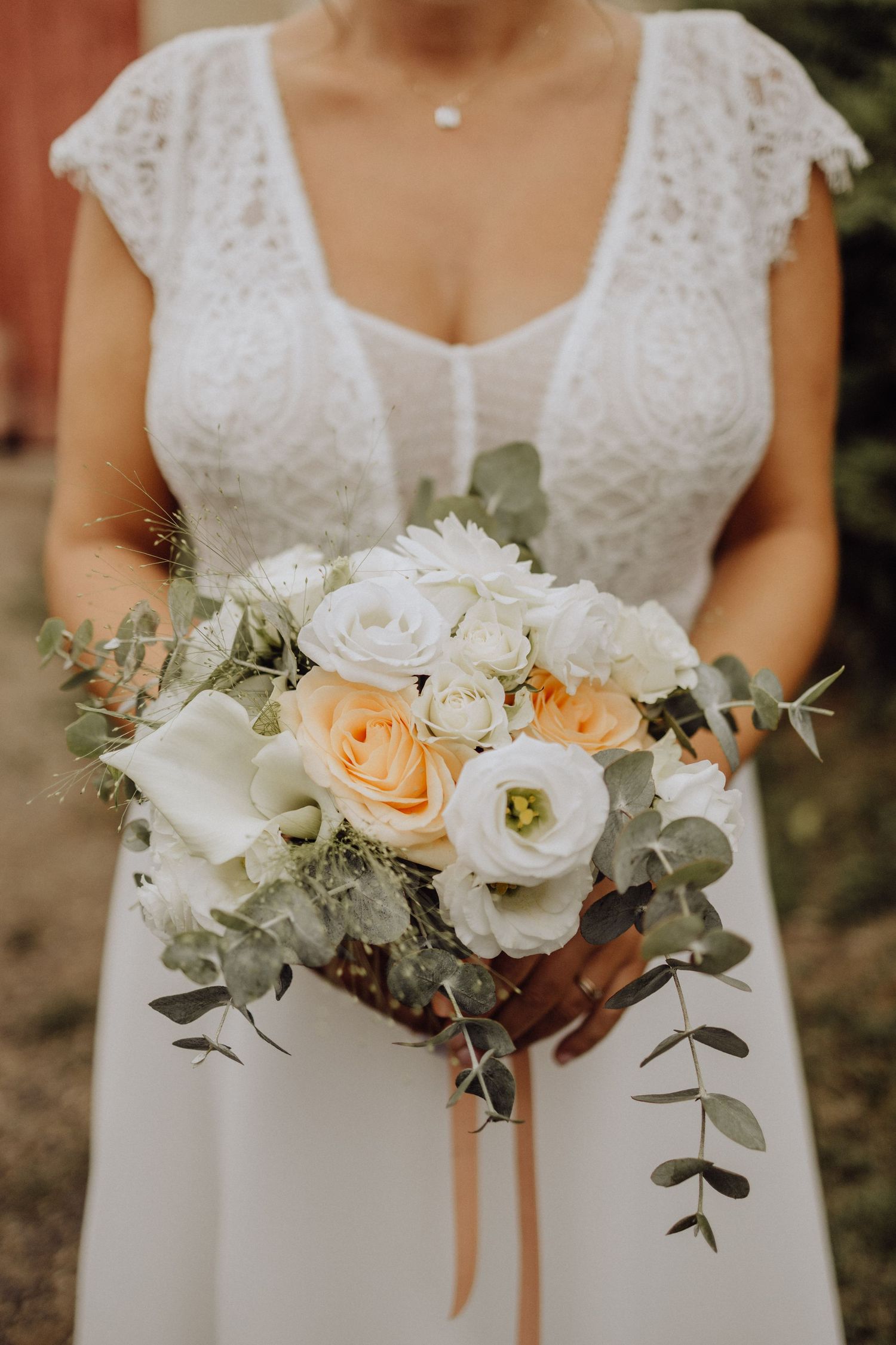 Photographe mariage Auvergne Rhône-Alpes – bouquet élégant de mariée avec roses blanches et pêche, eucalyptus et verdure.