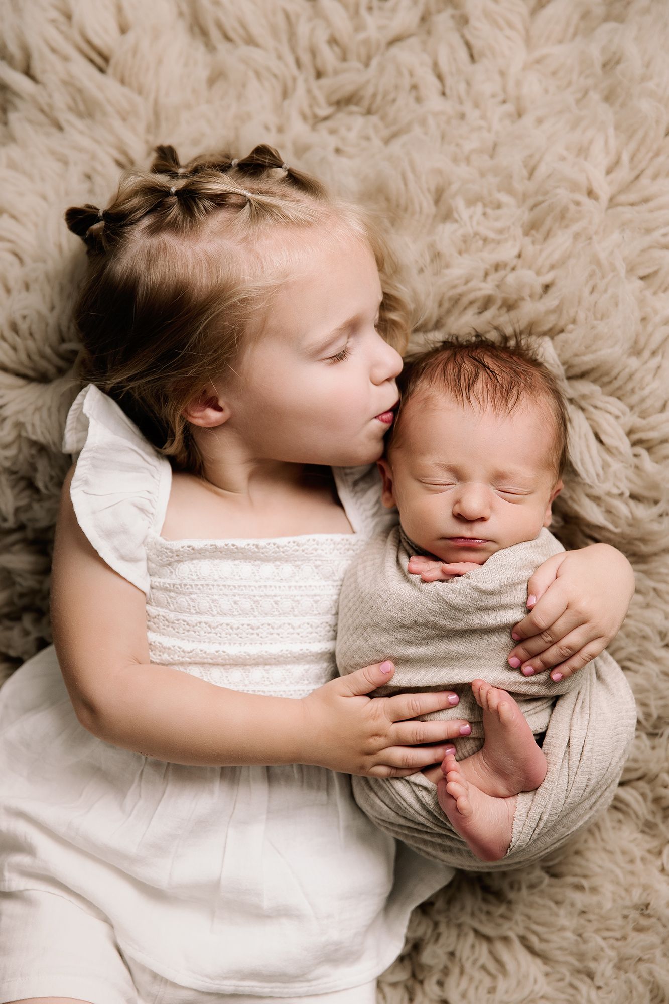 toddler cuddles little baby brother