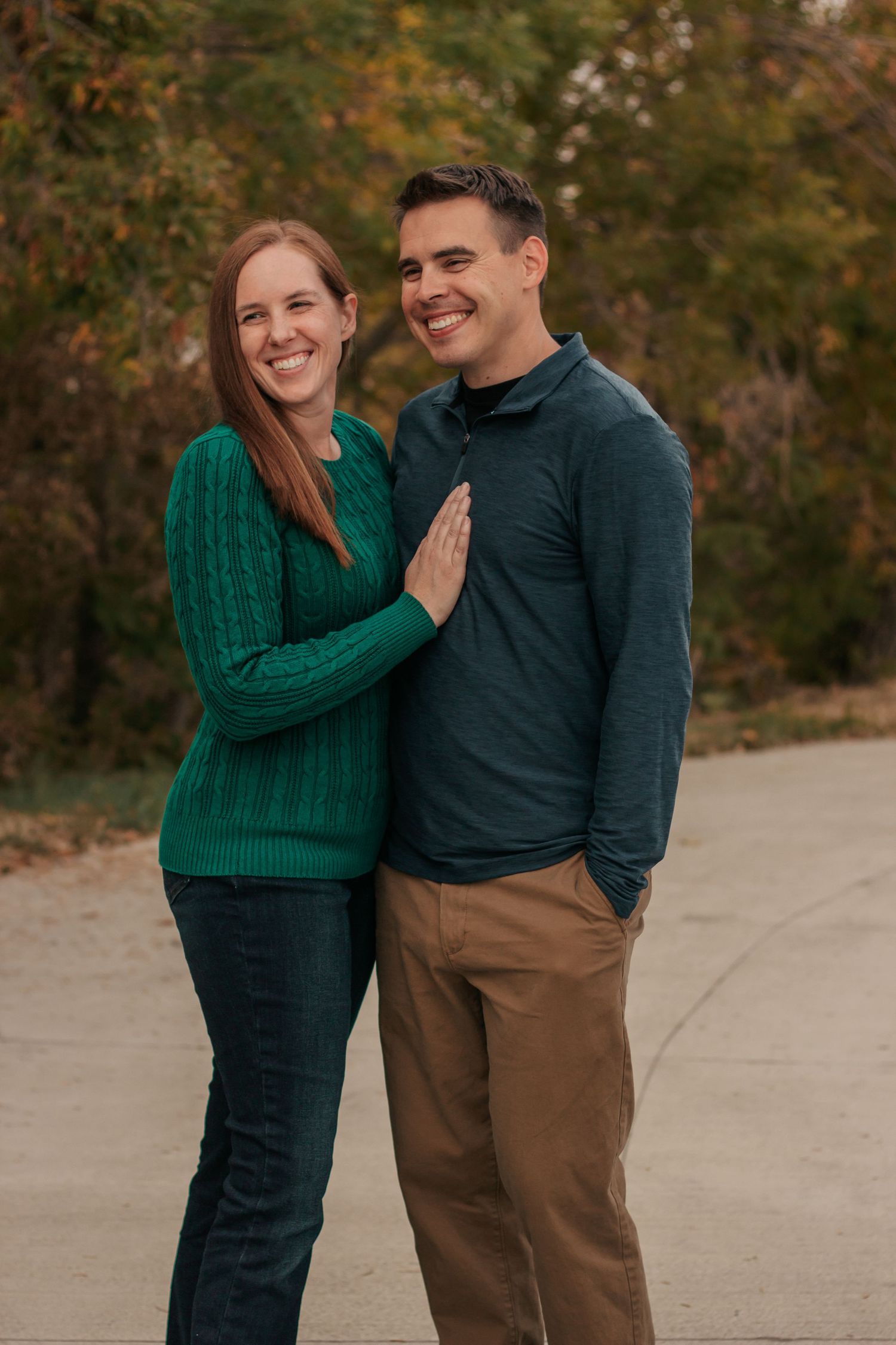 A couple in casual fall attire share tender moments outdoors. backdrop.| Motherhood + Maternity Photographer in Westminster,CO